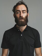 Intense portrait of a man with a full beard in a black polo shirt