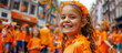 Kingsday celebration in the Netherlands. A smiling happy girl in orange clothes in Amsterdam during the King's Day national Dutch holiday or Holland football team support. Banner with copy space