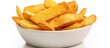 A close up of a bowl of french fries on a white surface