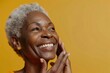 Happy beautiful african american older mature lady touching facial skin, looking away with perfect toothy smile, laughing, enjoying elderly beauty care, thinking on good skincare result