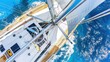 Aerial view of the deck of a single-mast yacht gliding along the surface of the water in the open sea. The open sea becomes a canvas for a yacht, painting a picture of tranquility and adventure.
