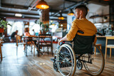 Fototapeta Boho - Man in wheelchair enjoys restaurant leisure in comfortable seating
