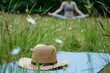 yoga pose in meadow, hat placed on mat corner