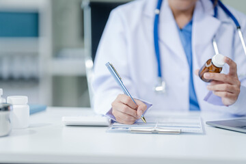 Wall Mural - Portrait of mix race asian middle age female doctor in white lab coat and stethoscope while consult online in laptop. advice on good mental health management and medical treatment costs.