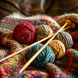 A closeup shot of woolen balls of yarn and wooden knitting needles arranged on a blanket, showcasing the creative art of textile crafting 