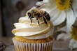 a bee resting on a swirl of cream atop a cupcake