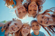 © MVProductions - Bunch of cheerful joyful cute little children playing together and having fun. Group portrait of happy kids huddling, looking down at camera and smiling. Low angle, view from below. Friendship concept