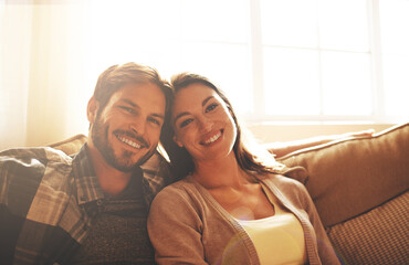 Poster - Love, happy and portrait of couple on sofa for bonding, loving relationship and relax together in home. Marriage, morning and man and woman on couch with smile, embrace and hugging in living room