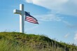 White cross on a hill with grass and USA flag, memorial day.