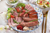 Fototapeta  - Top view of the plate with cold cuts and white sausage for trafitional Easter breakfast closeup