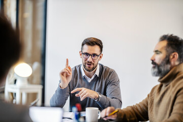 Fototapete - A young team lead is discussing ideas on a meeting at boardroom with his team.