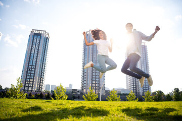 Canvas Print - Full body length photo of overjoyed young couple wearing casual outfit jumping bought apartments in new residential complex on background