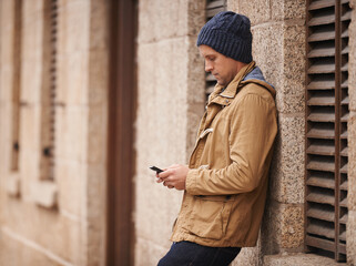 Relax, typing and man in city with phone for social media, networking and online text message in street. Travel, weekend and person on cellphone for website, internet search and chat in urban town