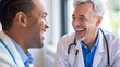 © kamonrat - two smiling male doctors in conversation, one in a white coat and the other in blue scrubs, both appearing cheerful in a brightly lit medical setting.
