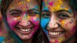 Dwie dziewczyny uśmiechają się, mają na sobie kolorową farbę, zapewne z okazji święta kolorów Holi. 