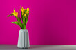 bouquet of yellow tulips in a vase on pink background, spring flowers for women, copy space
