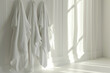Three clean white towels hanging on a sunny wall next to a window with bright sunlight streaming in