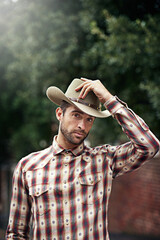 Canvas Print - Man, portrait and outdoor cowboy style, western culture and countryside ranch in Texas. Male person, hat and flannel fashion for farmer aesthetic, nature and plaid trend by trees or outside bush