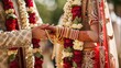 An Indian bride and groom in traditional wedding attire exchanging garlands during a ritual in their marriage ceremony.