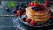 Rustic kitchen table setting with a stack of pancakes