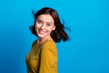 Wall Mural - photo of pretty adorable woman wear shirt wind blowing smiling empty space isolated blue color backg