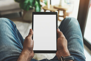 Male hands holding tablet with blank white empty screen, concept of technology use in everyday life, mockup tablet