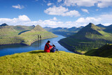 Fototapeta Konie - Tourist at Hvithamar Hill Top With Funningsfjordur Fjord View, Faroe Islands