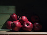 Fototapeta  - Red organic grown apples with in wooden box in bright sunlight with copyspace. Natural fruit from garden concept image.
