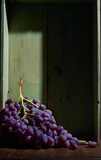 Fototapeta  - Bunch of ripe organic grown grapes in a wooden box in bright sunlight with copyspace. Natural fruit from garden concept image.