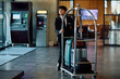 © Drazen - Young bellhop pushing luggage cart working in hotel.