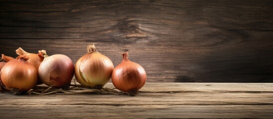 Poster - Three onions on a wooden table with a dark backdrop