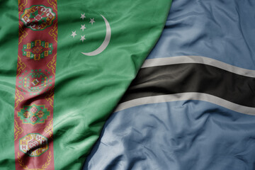 big waving national colorful flag of botswana and national flag of turkmenistan.