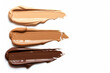 Set of three swatches of foundation texture. Light, medium and dark skin colors. White background. Space for text.