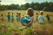 © lashkhidzetim - A child holds a globe made of moss and grass. Concept of environmental awareness and the importance of taking care of our planet