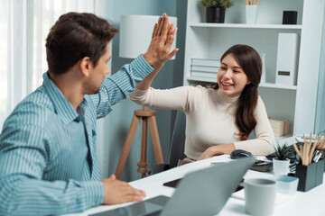 Smiling happy coworkers making hand high five also raising fist up of successful creative business project plan with highest profit value job in casual day at modern office at morning time. Postulate.