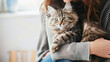 Close-up of a woman holding a cat in her arms