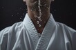 A man wearing a white shirt with a single water droplet escaping from his mouth, Sweat drop falling from a karate practitioner's forehead, AI Generated