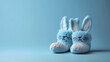 Close-up of newborn boy's blue booties. Advertising photo. Blue background of the photo studio. «It's a boy».