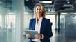 © OpticalDesign - Smiling mature businesswoman using her digital tablet in a modern office background, middle aged executive manager wearing a suit working with modern tools, ceo or employee at work hd