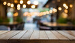 Empty old wooden table in front of abstract blurred bokeh background of a coffee shop full of people coming to use the service. Can be used for display or montage for show your products