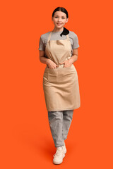 Wall Mural - Beautiful young waitress on orange background