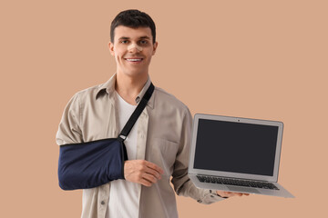 Sticker - Injured young man after accident with laptop on beige background