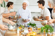 Friendly senior man, qualified chef, running culinary courses for mixed age group of ordinary passionate people, sharing professional secrets of cooking