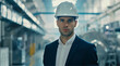 modern operational technology, young businessman wearing hard hat in a clean modern manufacturing plant