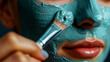 Close up of a beautiful woman applying a blue homemade DIY facial mask on her skin  Skincare routine and anti-aging treatment at spa healthy beauty treatment therapy