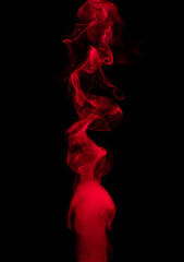 Canvas Print - Abstract background of chaotically mixing puffs of red smoke on a dark background