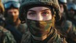 Focused female soldier with camouflaged face wearing helmet and military uniform among troops in field exercise. Strength and discipline in armed forces.