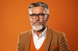 © Chacmool - Portrait of senior man with grey beard and eyeglasses on orange background