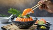 The hands were holding the chopsticks to hold the salmon sashimi. is an old traditional recipe