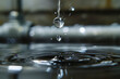 A close-up shot of a water droplet falling from a leaking pipe.